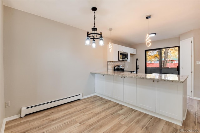 kitchen with stainless steel appliances, white cabinetry, kitchen peninsula, baseboard heating, and hanging light fixtures