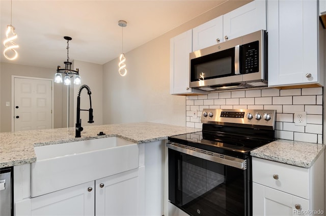 kitchen featuring white cabinetry, appliances with stainless steel finishes, sink, and hanging light fixtures