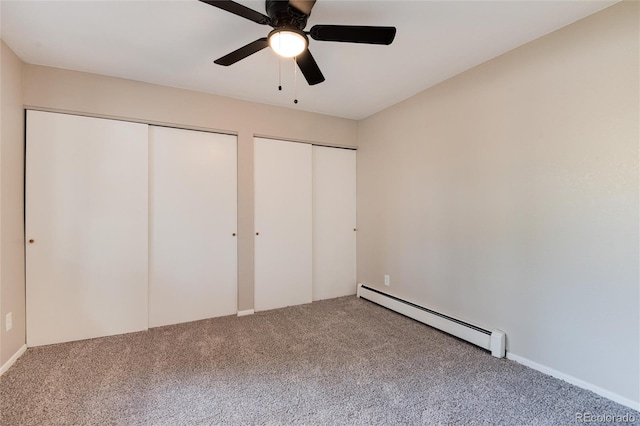 unfurnished bedroom with carpet, two closets, baseboard heating, and ceiling fan