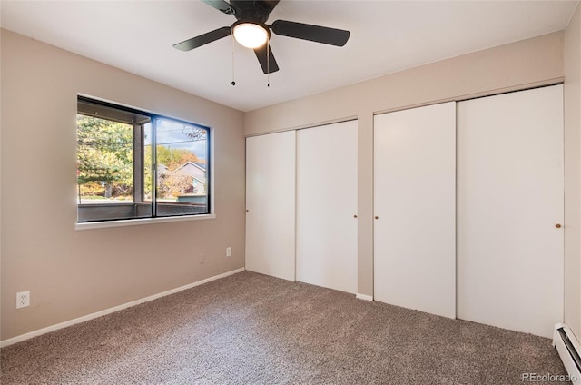 unfurnished bedroom with a baseboard radiator, carpet floors, ceiling fan, and two closets