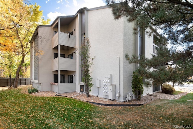 view of side of property with stucco siding and a balcony