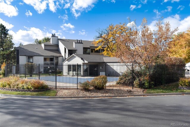 view of front of house with fence and stucco siding