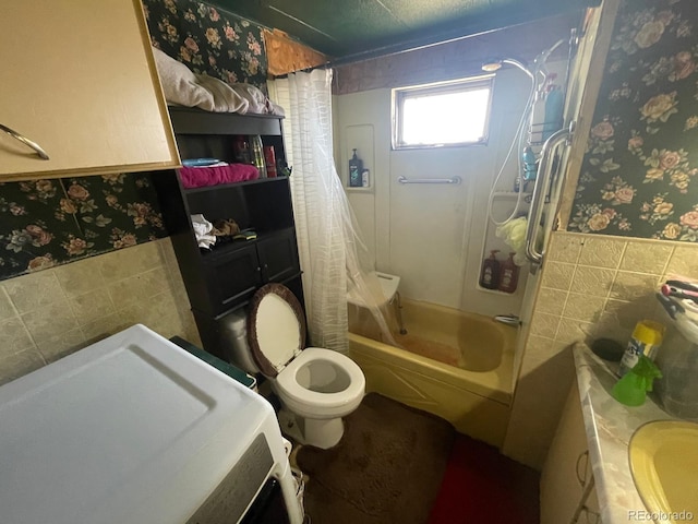 189 13th Ave, Cedaredge, CO 81413 - bathroom featuring a wainscoted wall, tile walls, shower / bath combo, and wallpapered walls