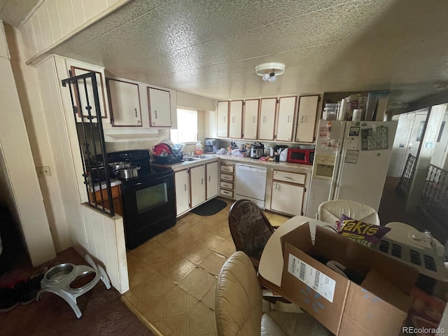 189 13th Ave, Cedaredge, CO 81413 - kitchen featuring under cabinet range hood, light floors, light countertops, white appliances, and white cabinetry