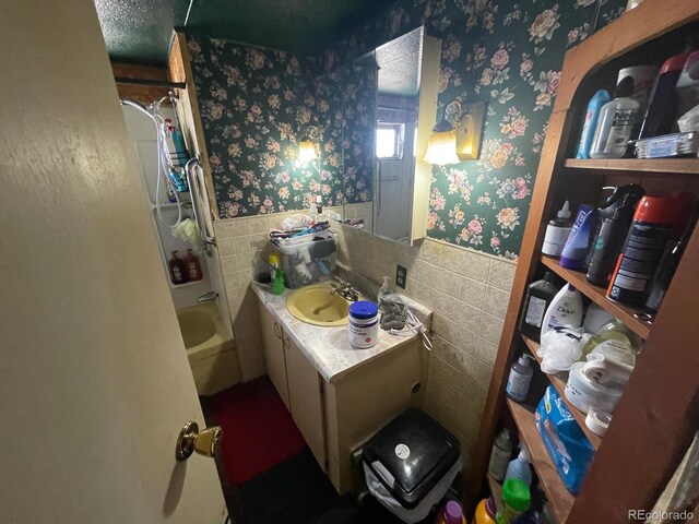 189 13th Ave, Cedaredge, CO 81413 - full bathroom featuring wallpapered walls, tile walls, shower / bath combo, and wainscoting