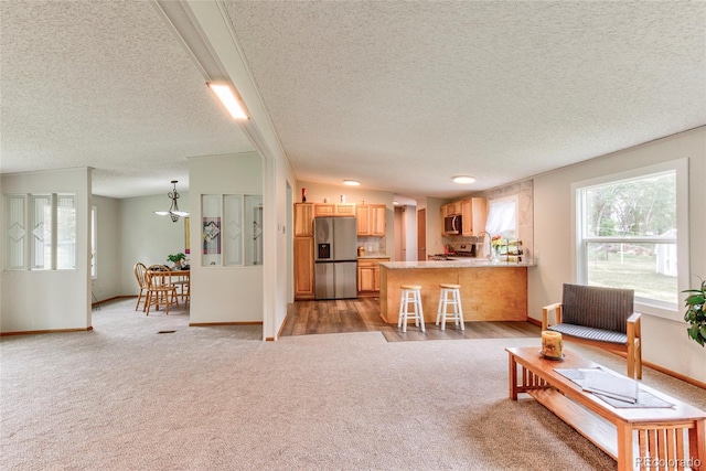 910 W Main St, Buena Vista, CO 81211 - living area featuring a textured ceiling, light carpet, and a chandelier