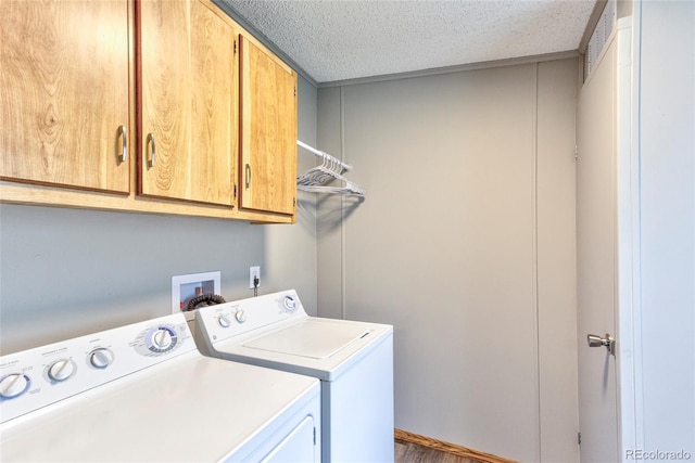 910 W Main St, Buena Vista, CO 81211 - laundry room featuring cabinet space, washing machine and clothes dryer, a textured ceiling, and wood finished floors