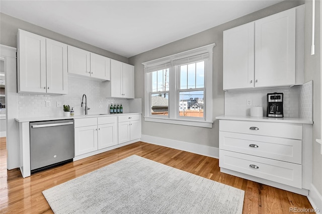 kitchen with a sink, light countertops, tasteful backsplash, and stainless steel dishwasher
