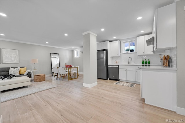 kitchen with white cabinetry, a sink, light countertops, stainless steel appliances, and extractor fan