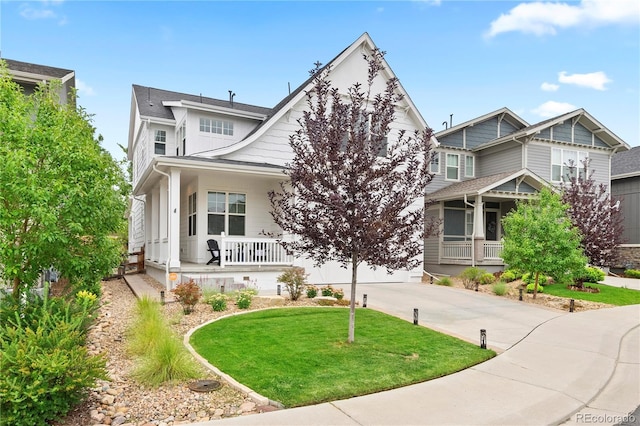 2027 Vallejo Loop, Broomfield, CO 80023 - view of front of house featuring a porch, concrete driveway, a garage, and a front lawn