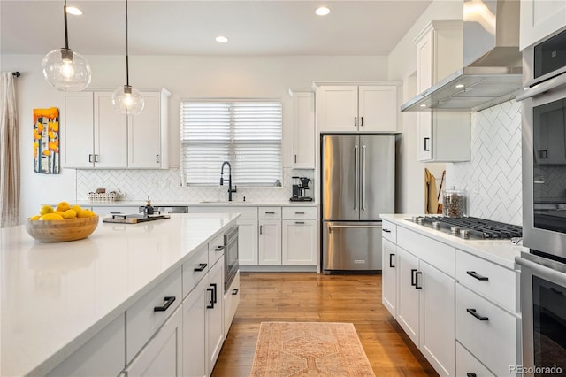 2027 Vallejo Loop, Broomfield, CO 80023 - kitchen featuring stainless steel appliances, wall chimney range hood, a sink, backsplash, and recessed lighting