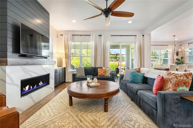 2027 Vallejo Loop, Broomfield, CO 80023 - living room featuring light wood-type flooring, ceiling fan, a large fireplace, and recessed lighting