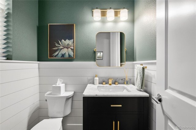 2027 Vallejo Loop, Broomfield, CO 80023 - bathroom featuring toilet, a wainscoted wall, and vanity