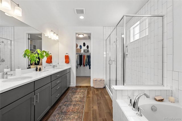 2027 Vallejo Loop, Broomfield, CO 80023 - full bath with a stall shower, a garden tub, double vanity, a walk in closet, and wood finished floors