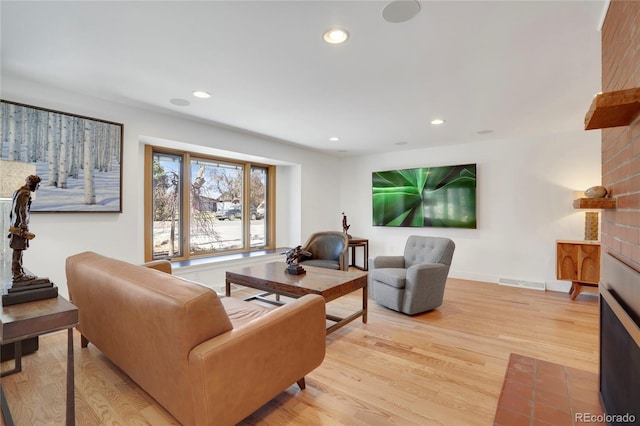 living area with light wood finished floors, baseboards, visible vents, and recessed lighting