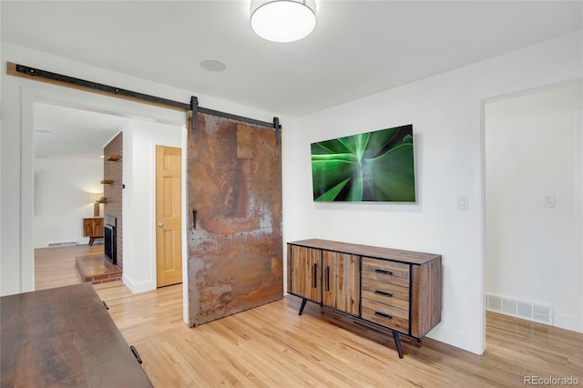 interior space with wood finished floors, visible vents, and a barn door