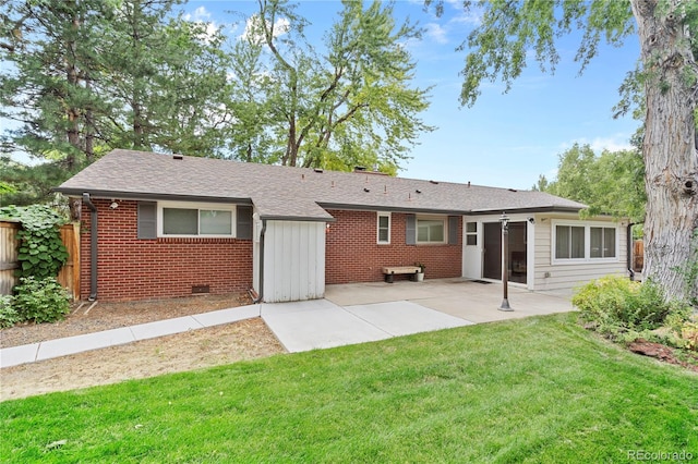 rear view of house with a patio area, crawl space, a lawn, fence, and brick siding