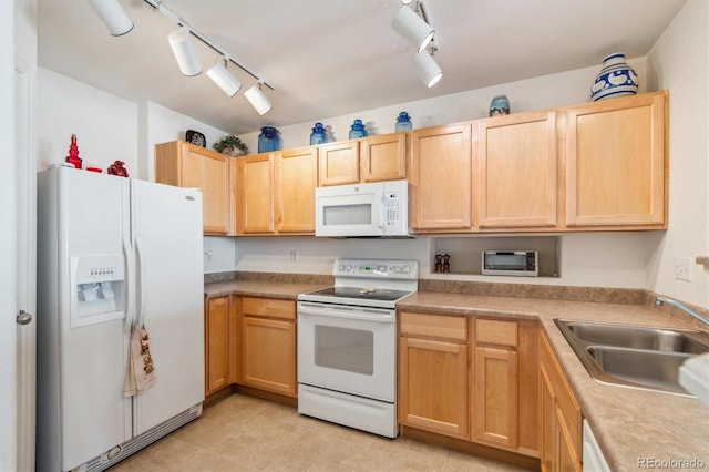 kitchen featuring white appliances, a sink, light countertops, light brown cabinetry, and track lighting