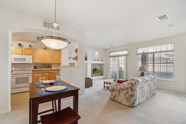 living area featuring visible vents and light carpet