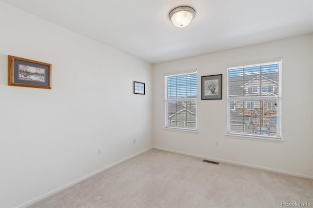 empty room with light carpet, baseboards, and visible vents