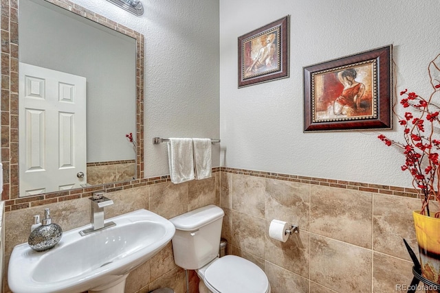 5625 S Buchanan St, Aurora, CO 80016 - bathroom with a sink, toilet, tile walls, and a wainscoted wall