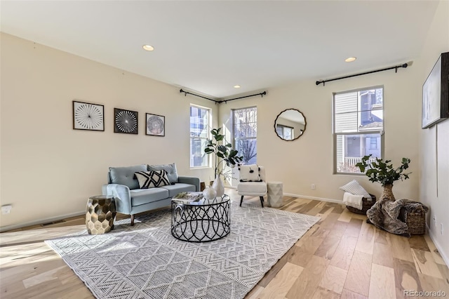 living room with recessed lighting, visible vents, baseboards, and wood finished floors