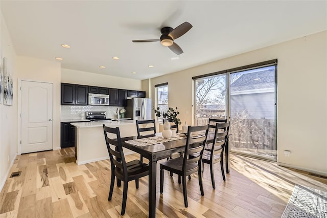 dining area with light wood finished floors, visible vents, and recessed lighting