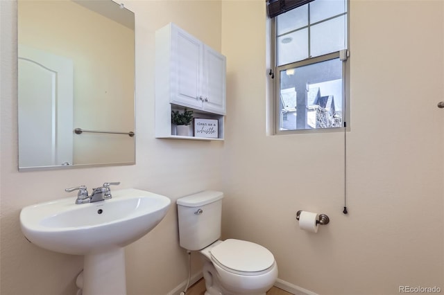 bathroom with toilet and baseboards