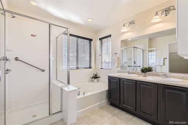 bathroom featuring a stall shower, double vanity, a sink, and a bath