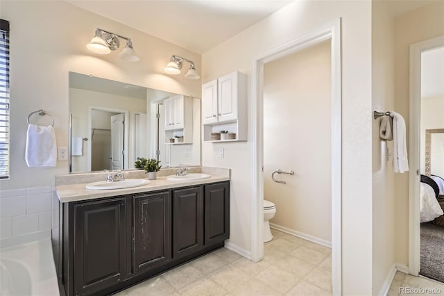 bathroom with vanity, a bath, and toilet