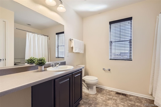 full bathroom with baseboards, visible vents, vanity, and toilet