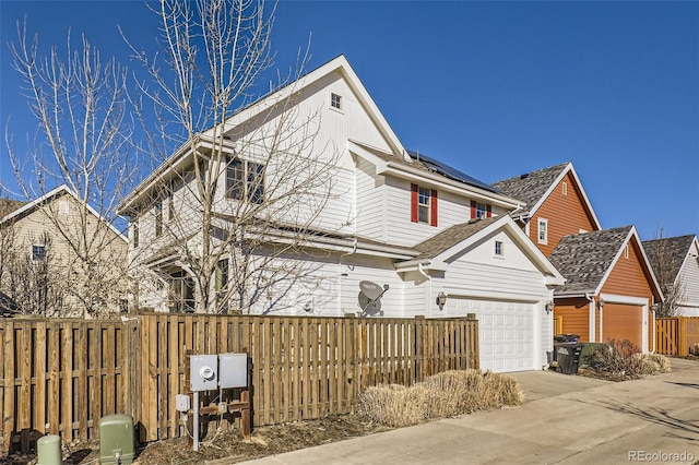 view of front of property with a garage, fence, and concrete driveway