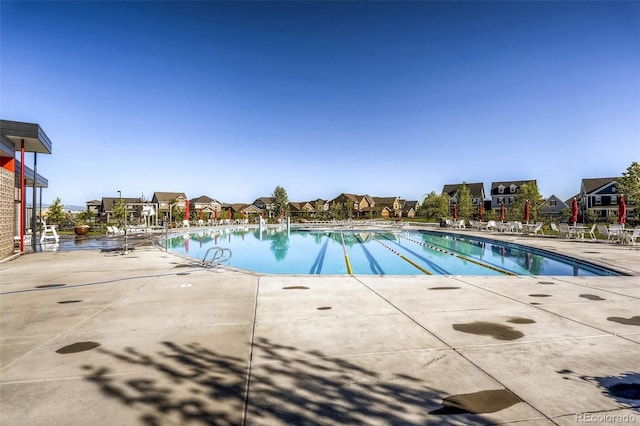 pool featuring a patio area and a residential view