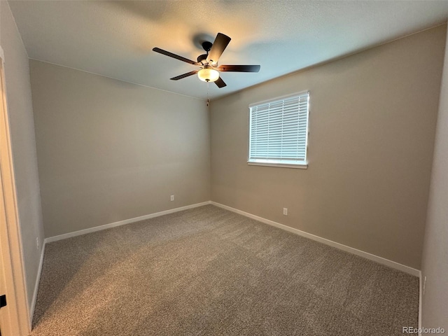 spare room with ceiling fan, a textured ceiling, carpet, and baseboards