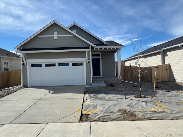 view of front facade featuring driveway, an attached garage, and fence