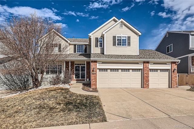 traditional home featuring a shingled roof, concrete driveway, brick siding, and covered porch