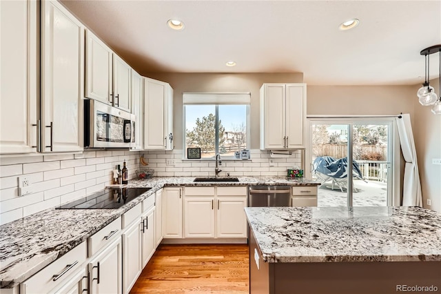 kitchen featuring a healthy amount of sunlight, light wood-type flooring, appliances with stainless steel finishes, and a sink