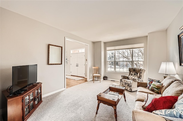 living area featuring carpet flooring and baseboards