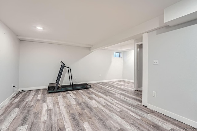 below grade area featuring baseboards and wood finished floors