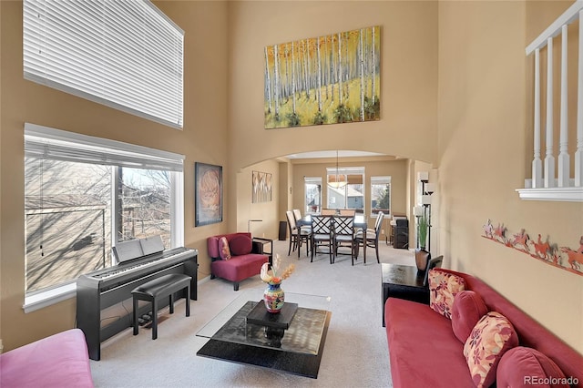 carpeted living room with a high ceiling