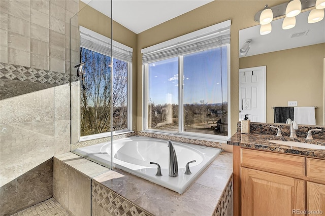 bathroom with vanity and tiled bath