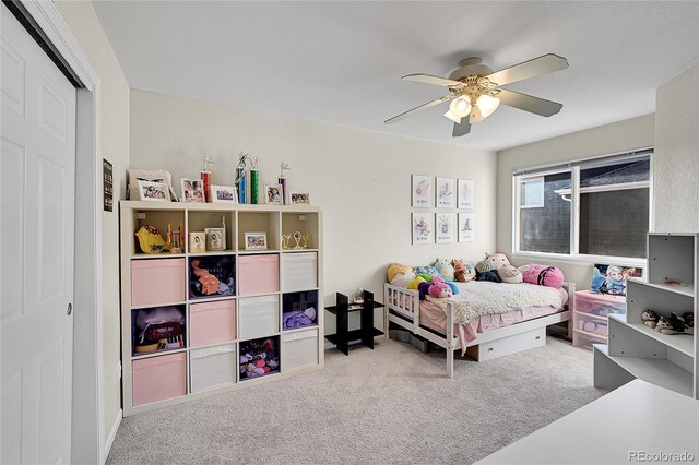 bedroom featuring ceiling fan, a closet, and light colored carpet