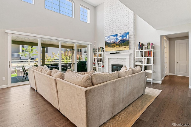 living room featuring dark hardwood / wood-style flooring, plenty of natural light, and a high ceiling