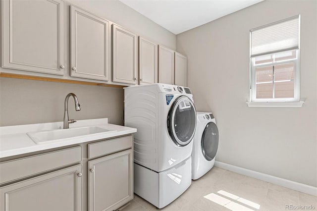 washroom featuring cabinets, light tile patterned floors, sink, and washing machine and clothes dryer