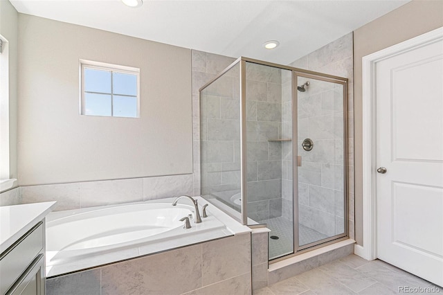 bathroom featuring shower with separate bathtub and vanity