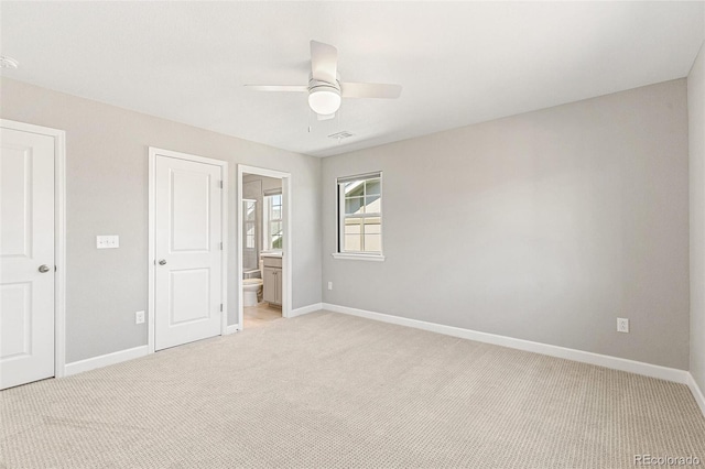 unfurnished bedroom with light carpet, connected bathroom, and ceiling fan