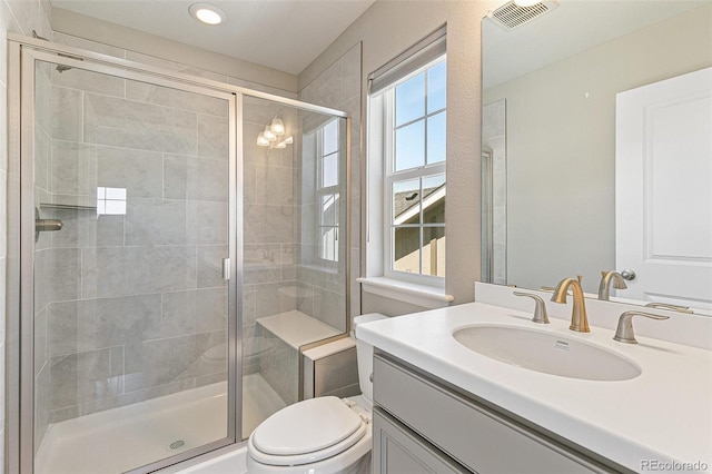 bathroom with vanity, toilet, and a shower with shower door