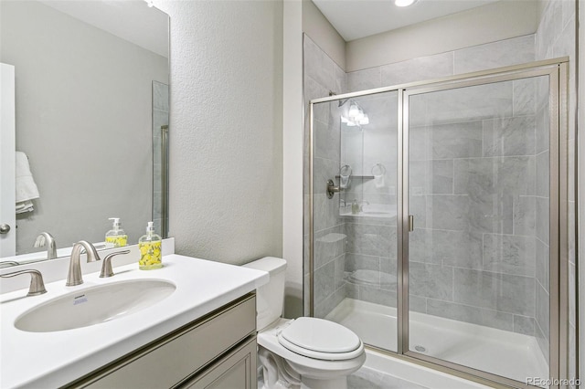 bathroom featuring toilet, vanity, and walk in shower