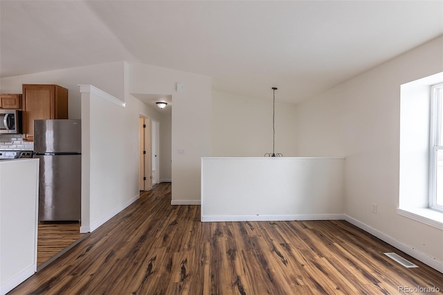 interior space featuring visible vents, baseboards, appliances with stainless steel finishes, backsplash, and dark wood-style floors