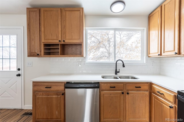 kitchen featuring a sink, plenty of natural light, light countertops, and stainless steel dishwasher